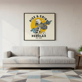 Framed artwork with 'Rise & Grind Hobolax' design above a gray sofa in a living room.